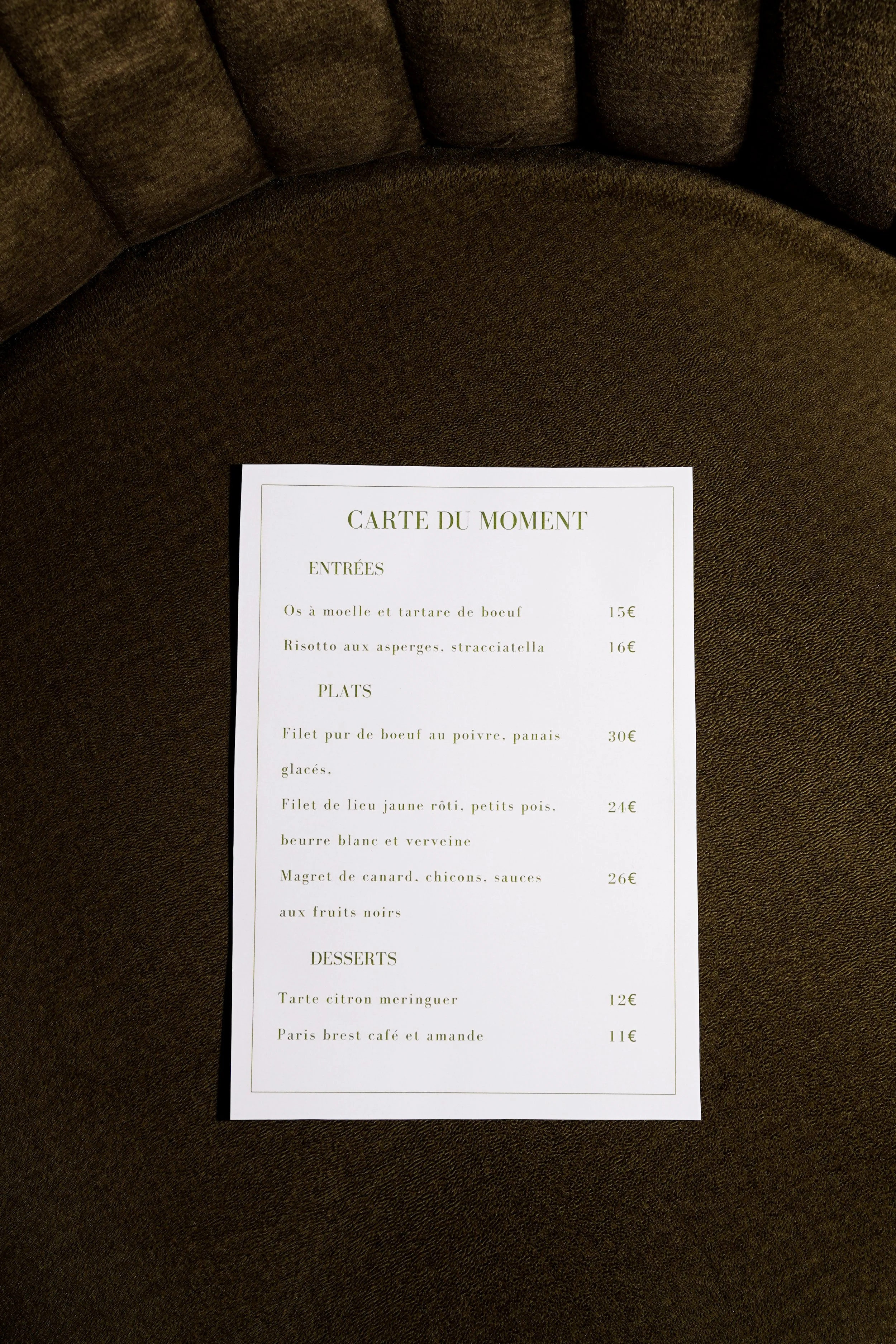 Carte du menu de restaurant avec entrées, plats et desserts sur une chaise marron.