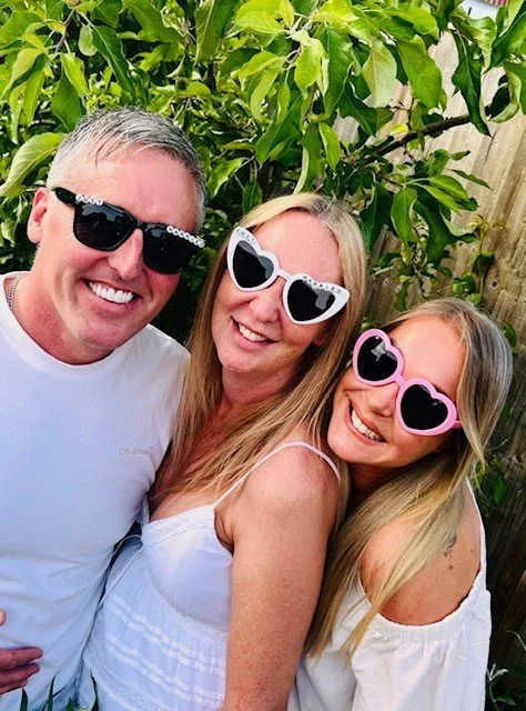 Wedding celebrant Stephanie from Pinky Promise Ceremonies smiling with a bride and groom during an outdoor garden wedding ceremony