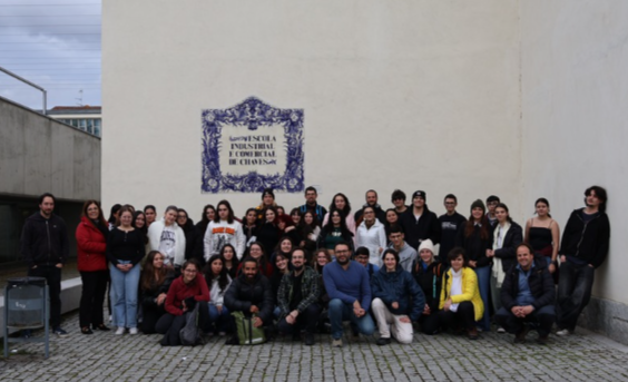 Gruppo di persone davanti a un muro con una scritta che indica un'istituzione di ingegneria industriale e commerciale.