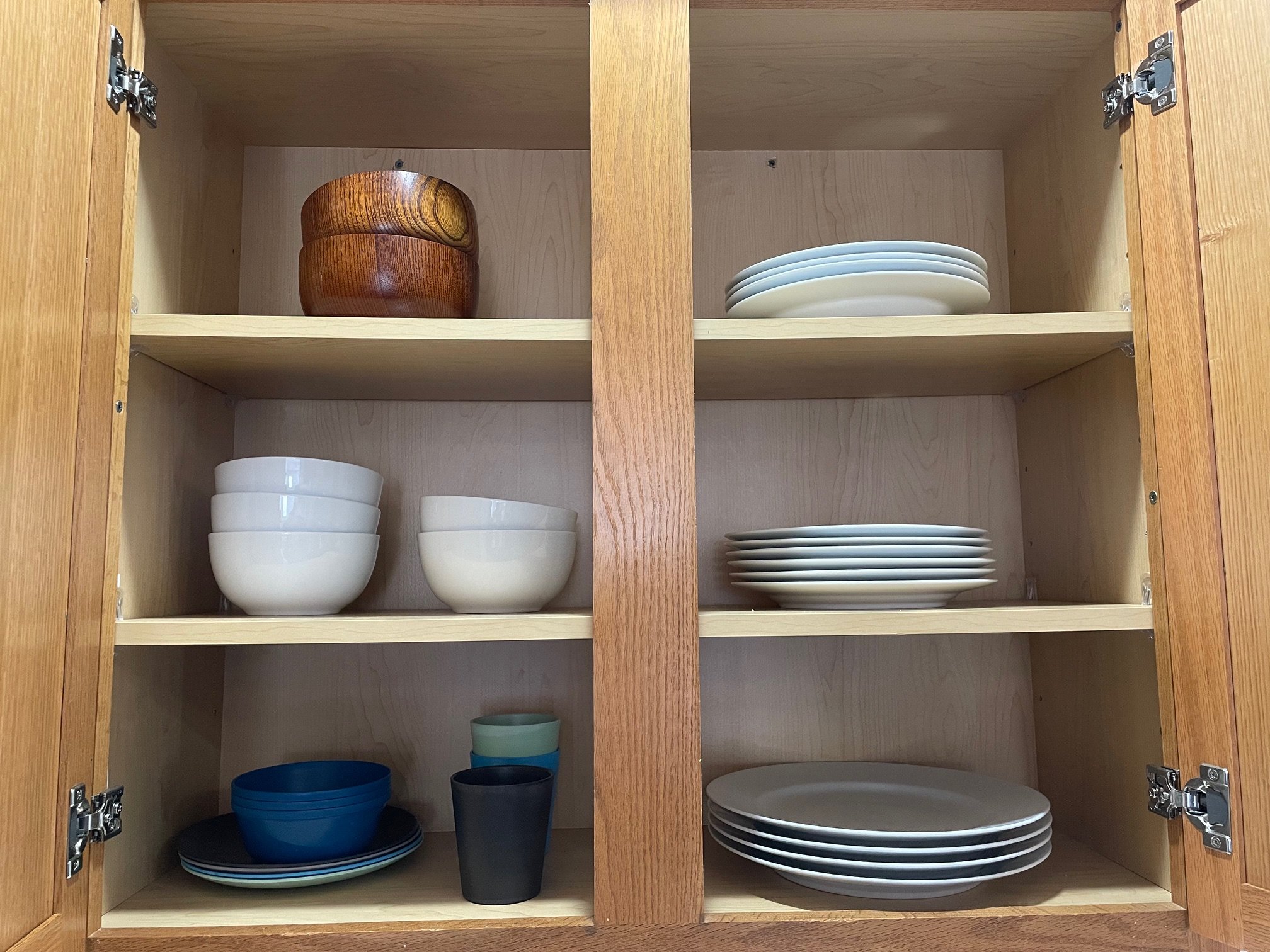 Kitchen cabinet with bowls, cups, and plates