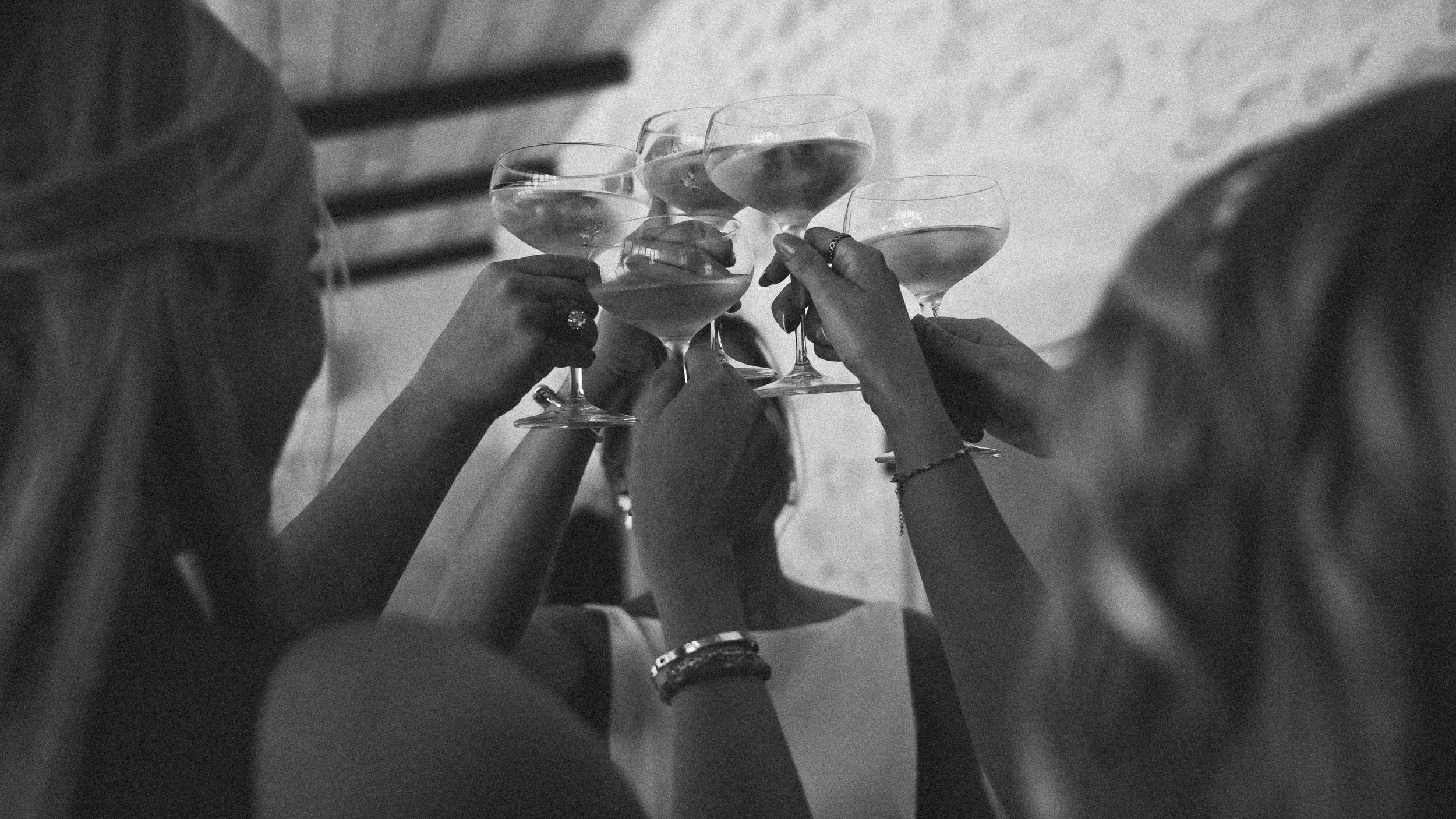 Groupe de personnes trinquant avec des verres à cocktail lors d'une fête ou d'un rassemblement social.
