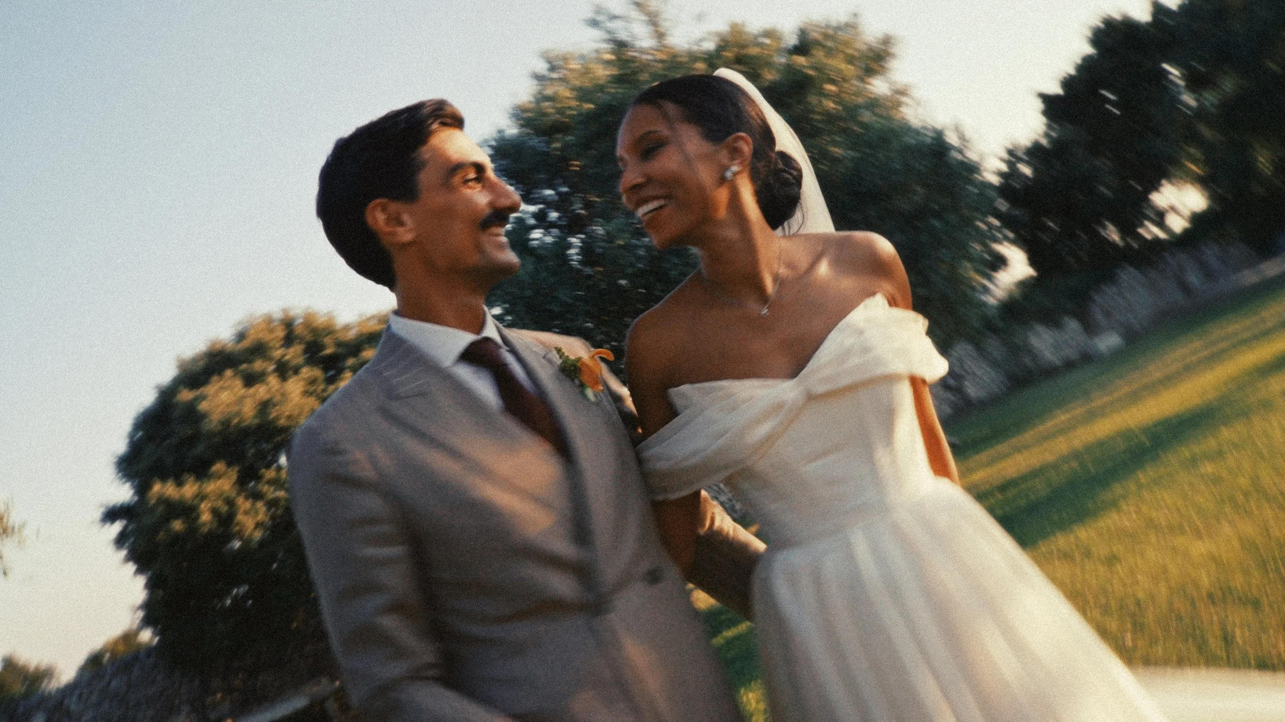 Un couple souriant lors de leur mariage en plein air au coucher du soleil.
