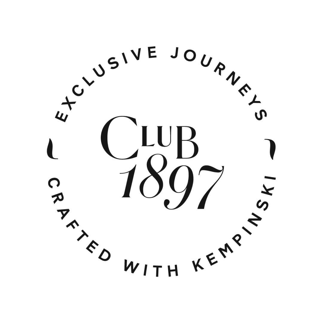 Black and white circular logo for Club 1897 with the text 'Exclusive Journeys' and 'Crafted with Kempinski' surrounding 'Club 1897' in the center.
