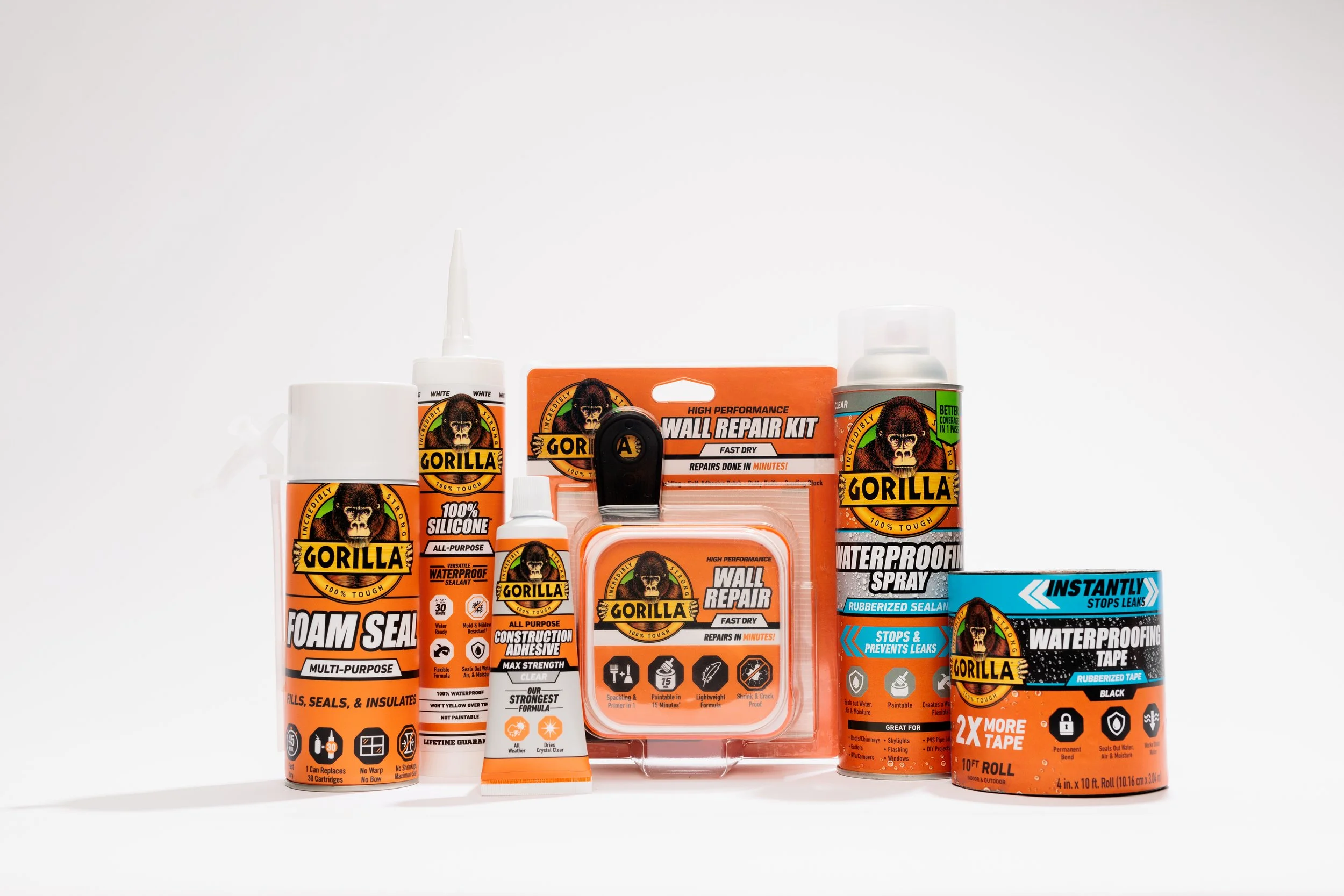 A collection of Gorilla brand construction and repair products including foam sealant, silicone sealant, wall repair kit, waterproof spray, waterproof tape, and waterproof tape roll on a white background.