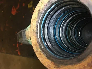 Detailaufnahme eines Hydraulikzylinders mit sichtbaren Dichtungen und Führungsringen, geprüft im Rahmen der Maschinenreparatur.