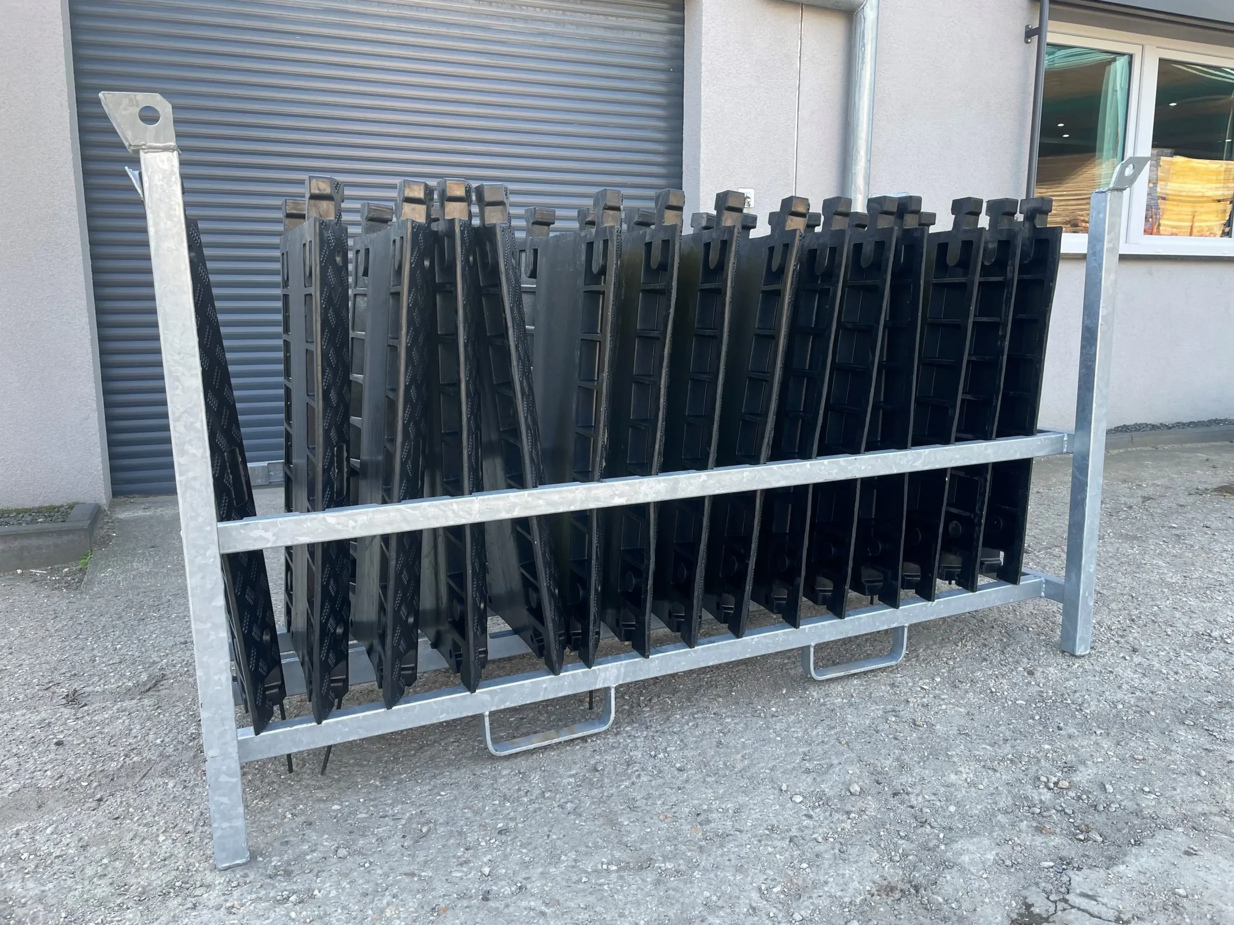 Schwarze Kabelbrücken in einem robusten Transportgestell aus Metall zur Miete für den sicheren Leitungsschutz auf Baustellen.