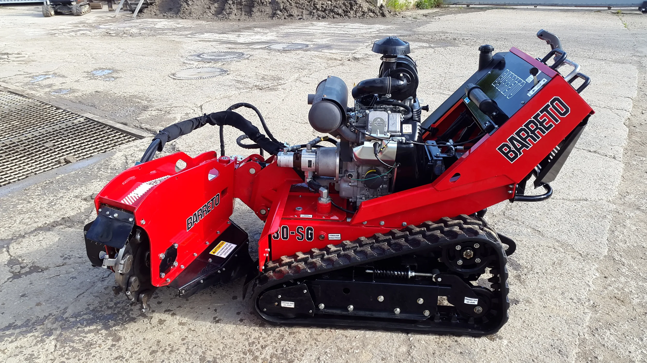 Rot-schwarze Wurzelfräse auf Raupenfahrwerk der Marke Barreto (Modell 30-SG) zur Miete für das professionelle und effiziente Entfernen von Baumstümpfen und Wurzelwerk.