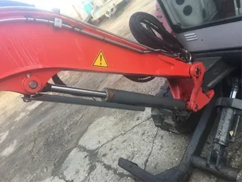 Hydraulikzylinder am Ausleger einer Baumaschine, sichtbar bei Wartungs- und Reparaturarbeiten vor Ort.