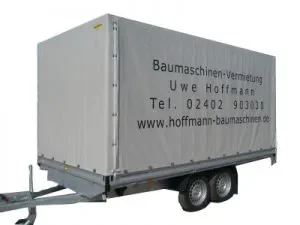 Zweiachsiger Planenanhänger mit Aufdruck „Baumaschinen-Vermietung Uwe Hoffmann“ und Kontaktangaben.