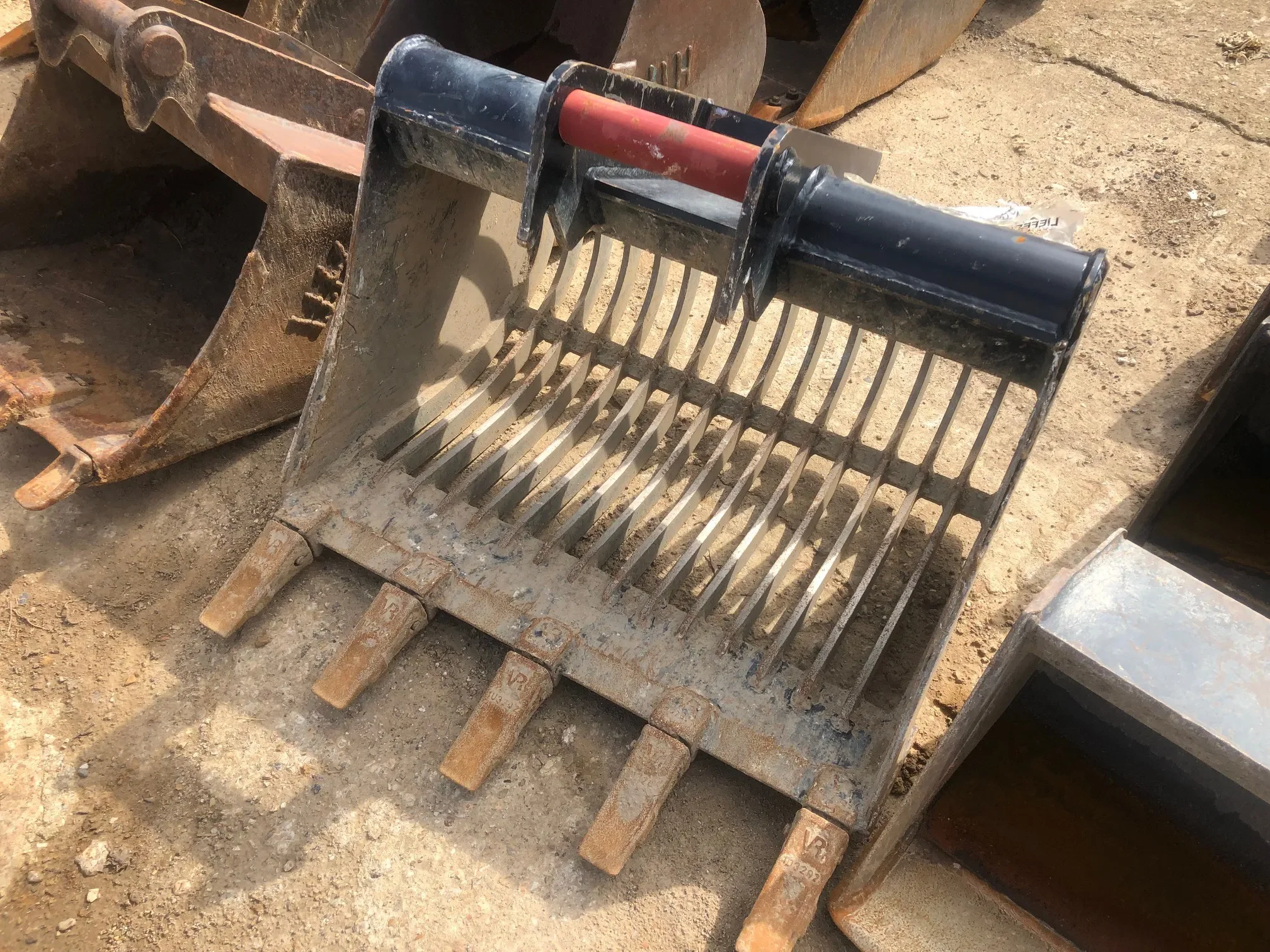 Robuster Sieblöffel mit Zähnen als Bagger-Anbaugerät für die Materialsortierung zur Miete.