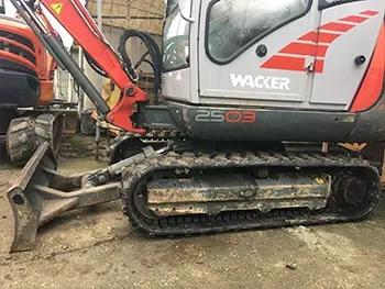 Seitenansicht eines Wacker-Neuson-Kettenbaggers auf dem Hof, aufgenommen im Rahmen von Wartung und Maschinenreparatur.