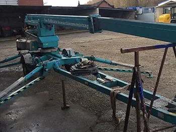 Mobiler Anhängerkran auf dem Hof, abgestützt und bereit für Wartung bzw. Reparaturarbeiten.