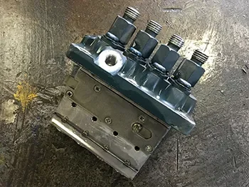 Hydraulikventilblock mit mehreren Anschlüssen auf der Werkbank, vorbereitet für Prüfung und Instandsetzung.