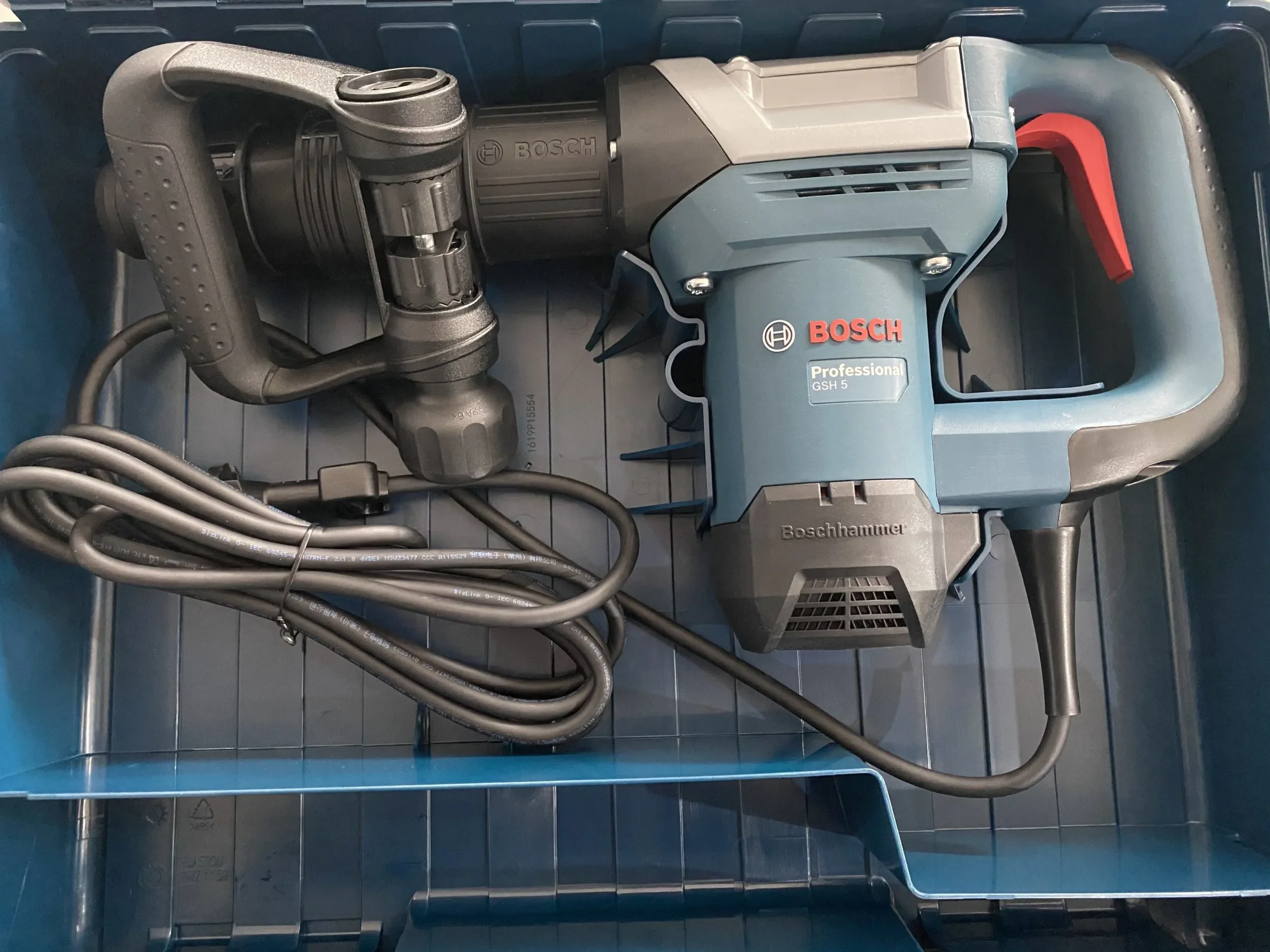 Blauer elektrischer Meißelhammer der Marke Bosch Professional im Transportkoffer zur Miete für Stemm- und Abbrucharbeiten.