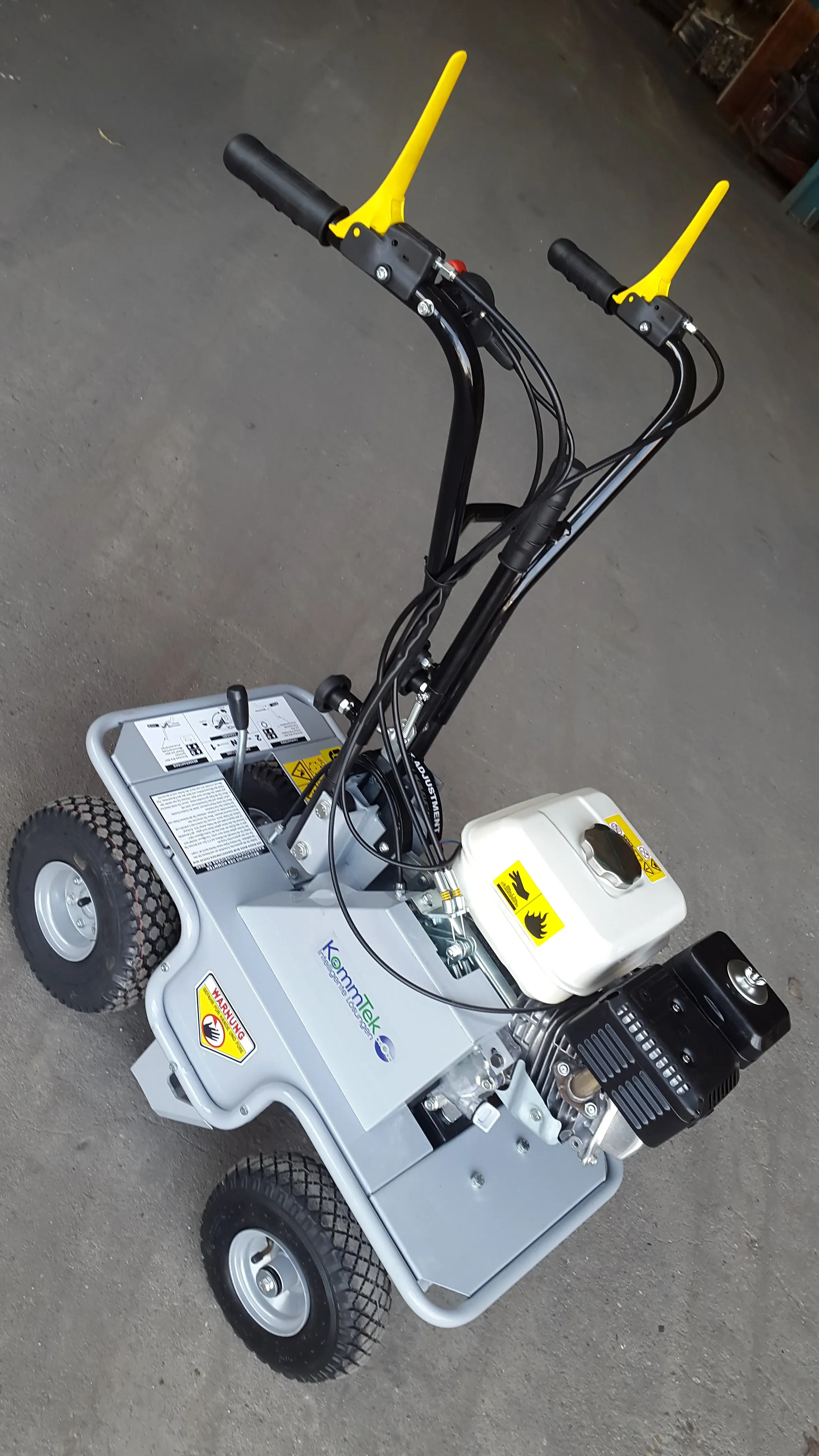 Graue benzinbetriebene Rasenschälmaschine der Marke KommTek zur Miete für das professionelle und präzise Abtragen von Altrasen.