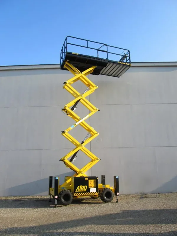 Gelbe Scherenarbeitsbühne mit ausgefahrener Plattform vor einer Gebäudewand.