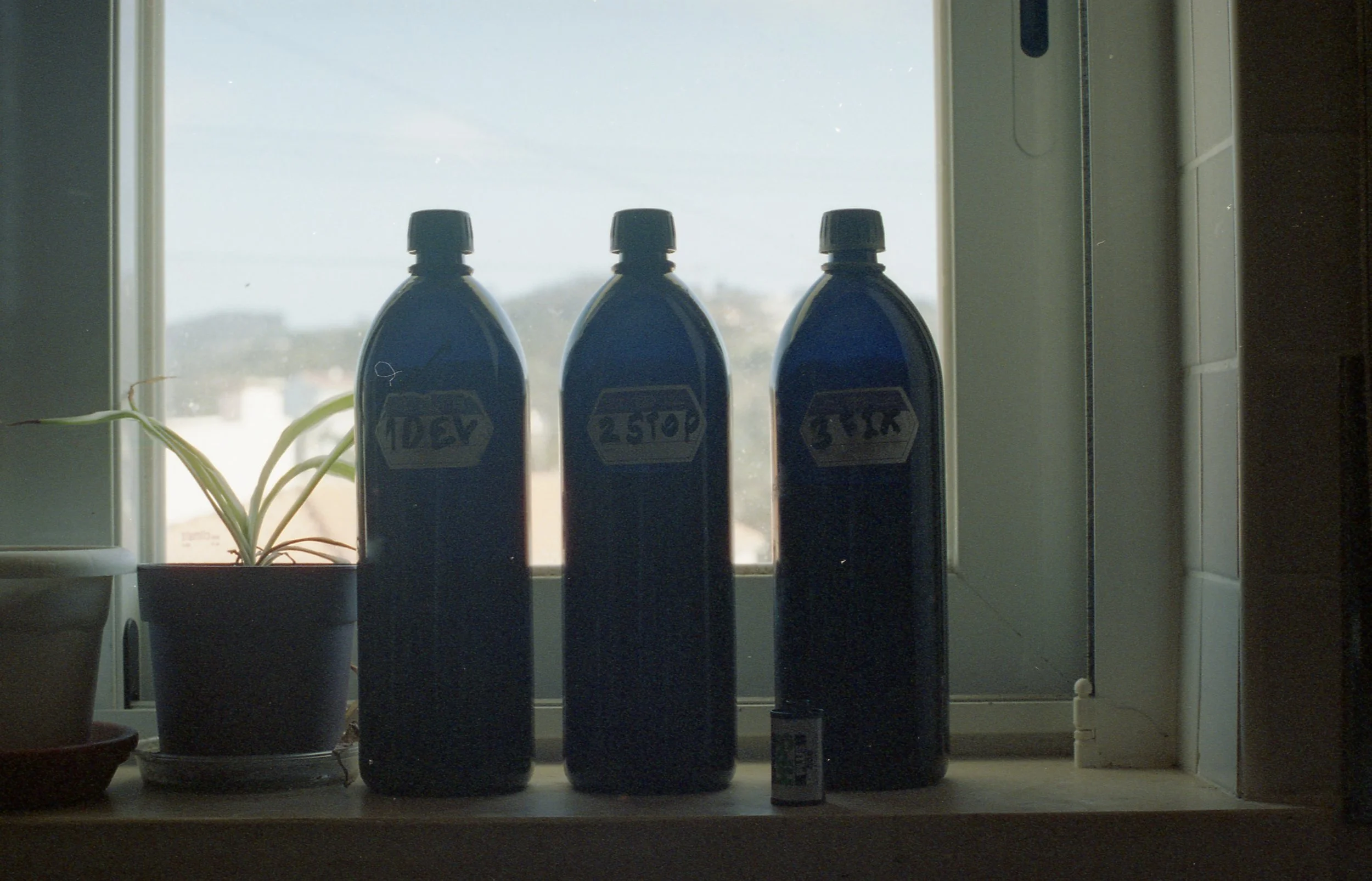 Person pouring dark liquid into a clear measuring container on a kitchen counter.