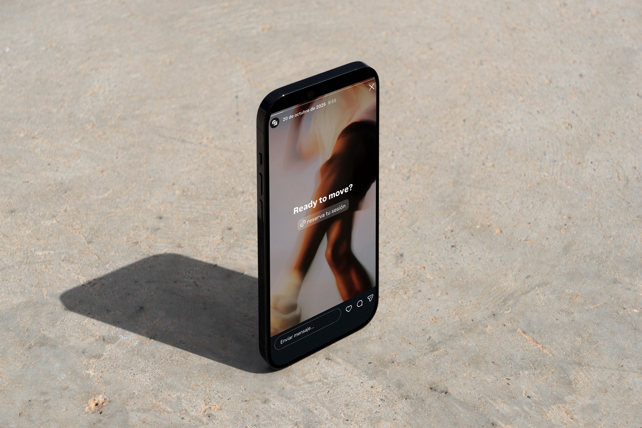 Teléfono inteligente en la arena con pantalla mostrando texto "¿Listo para moverte?" y opción para reservar sesión.