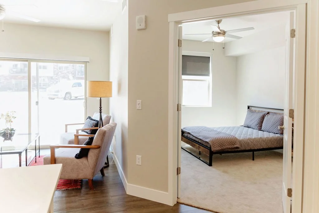 Photo showing bedroom and living room from the kitchen of the one-bedroom condo.