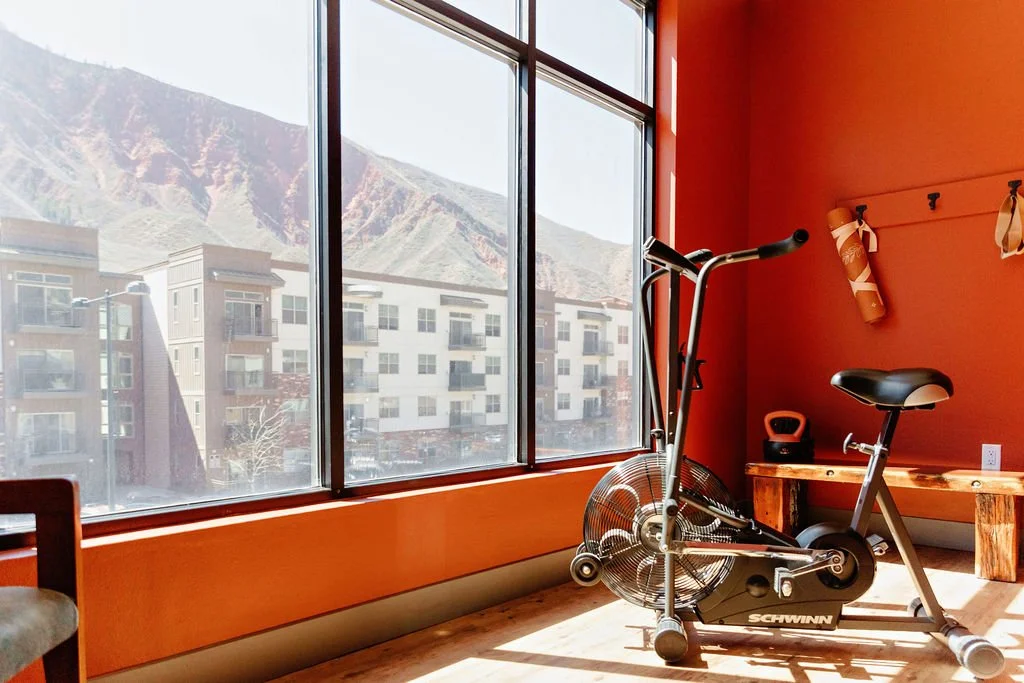 Workout space with bike, small weights, and yoga mat