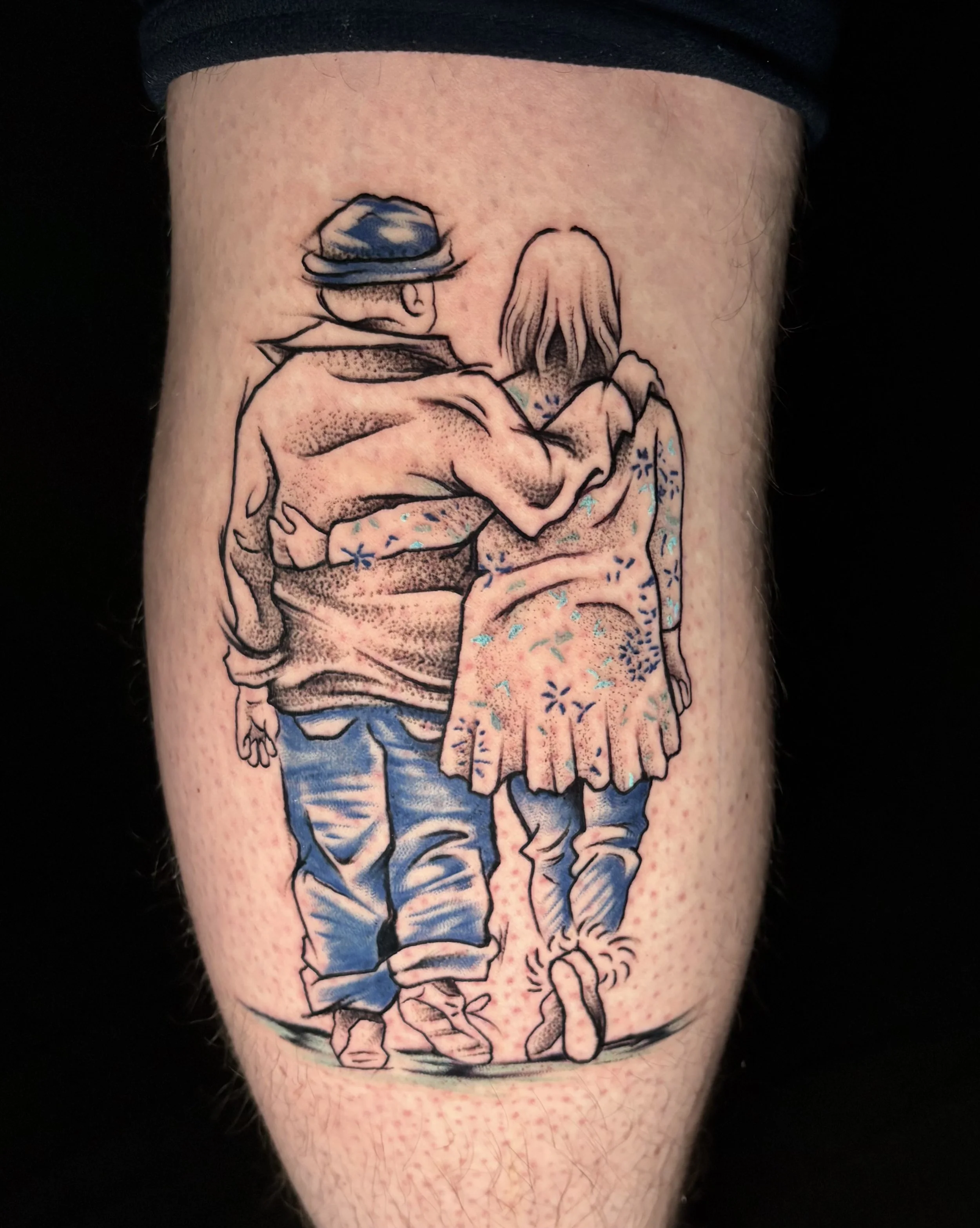 Tattoo of a boy and a girl walking together with their arms around each other, viewed from behind, with the boy wearing a hat and the girl wearing a dress.