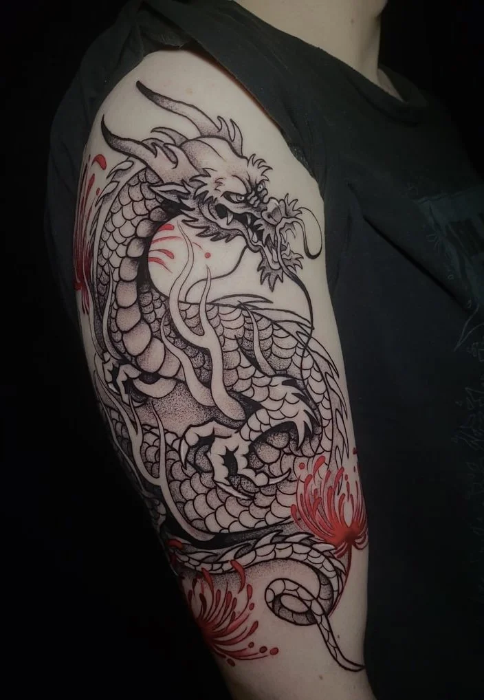Black tattoo of a dragon with scales, whiskers, and sharp claws on a person's upper arm, with red accents resembling flames or color splashes around the tail.