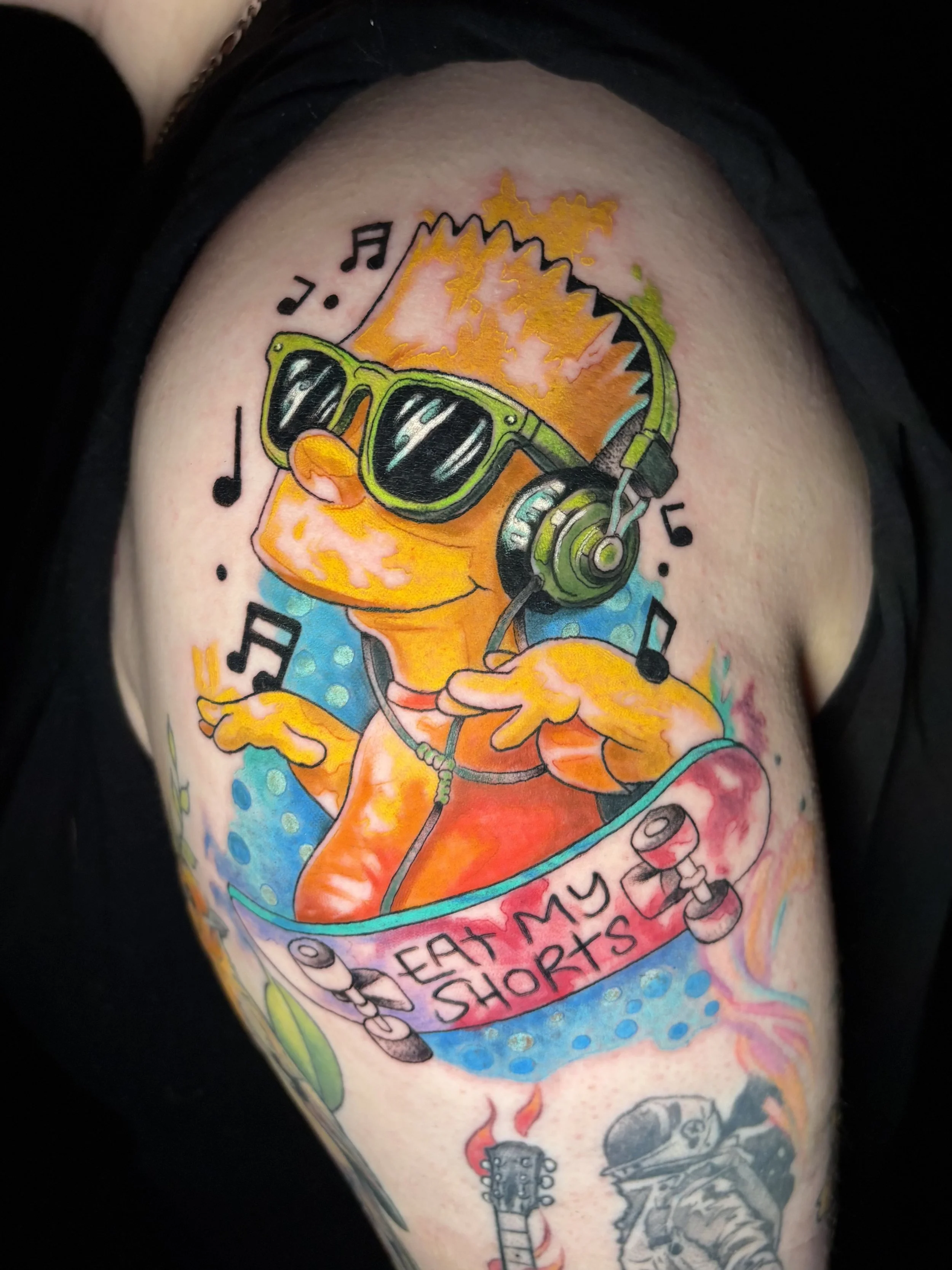 Colorful tattoo of a duck wearing sunglasses and headphones, with musical notes, a banner reading 'Eat My Shorts,' and a guitar below.