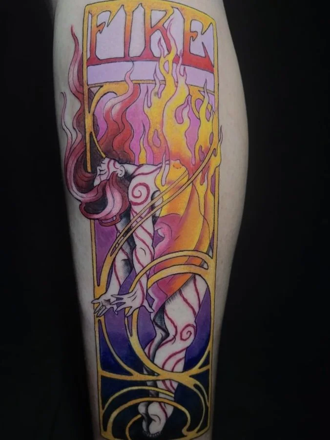 A colorful tattoo of a mythical unicorn with flames and intricate gold detailing, with the word "FIRE" at the top.