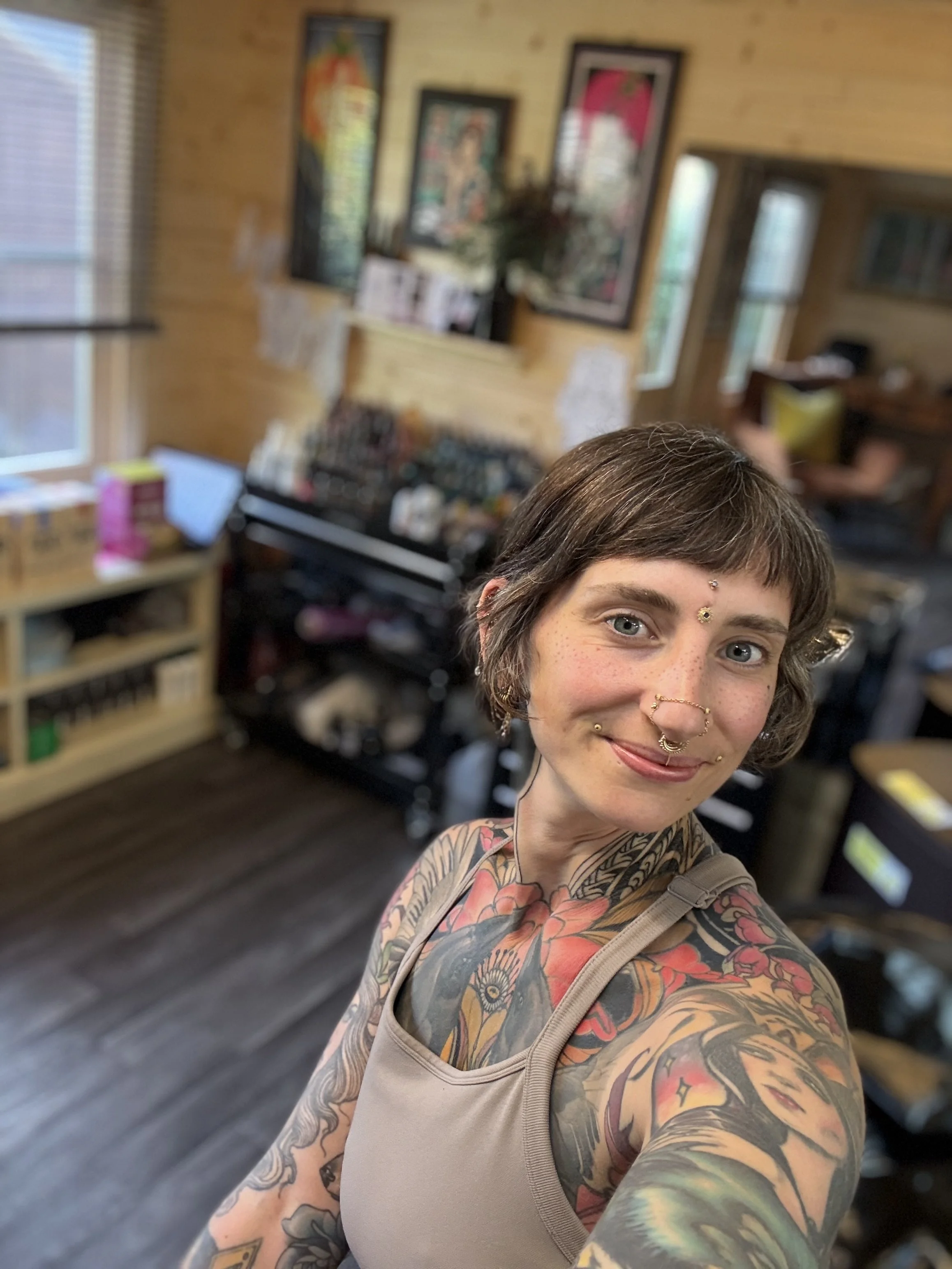Tattooed woman in tattoo studio space tattoo artist