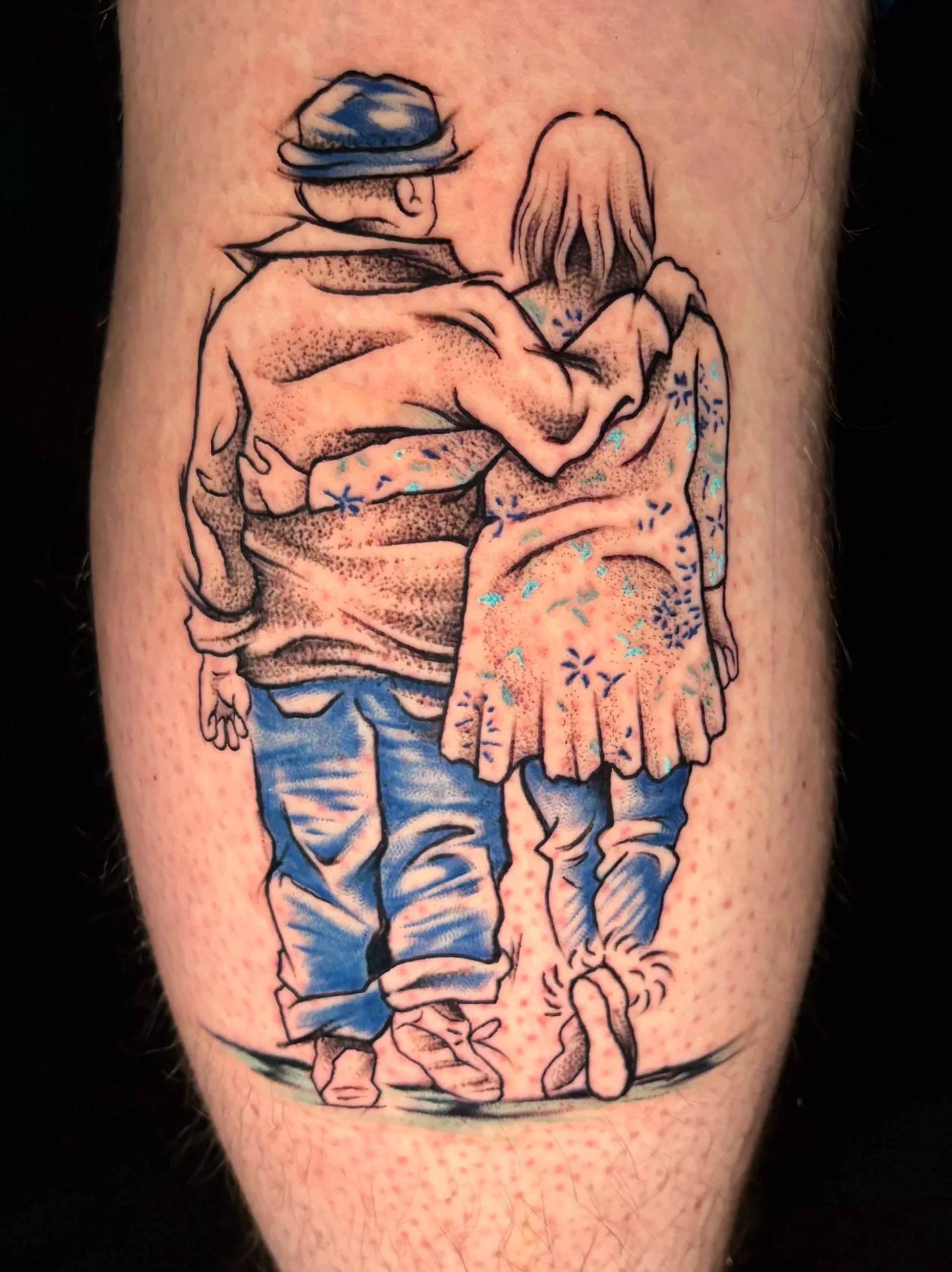 Tattoo of a man and woman walking arm in arm, with the man wearing a hat and the woman wearing a dress, depicted in a sketch style with black outlines and shading, some coloring in blue and peach tones.