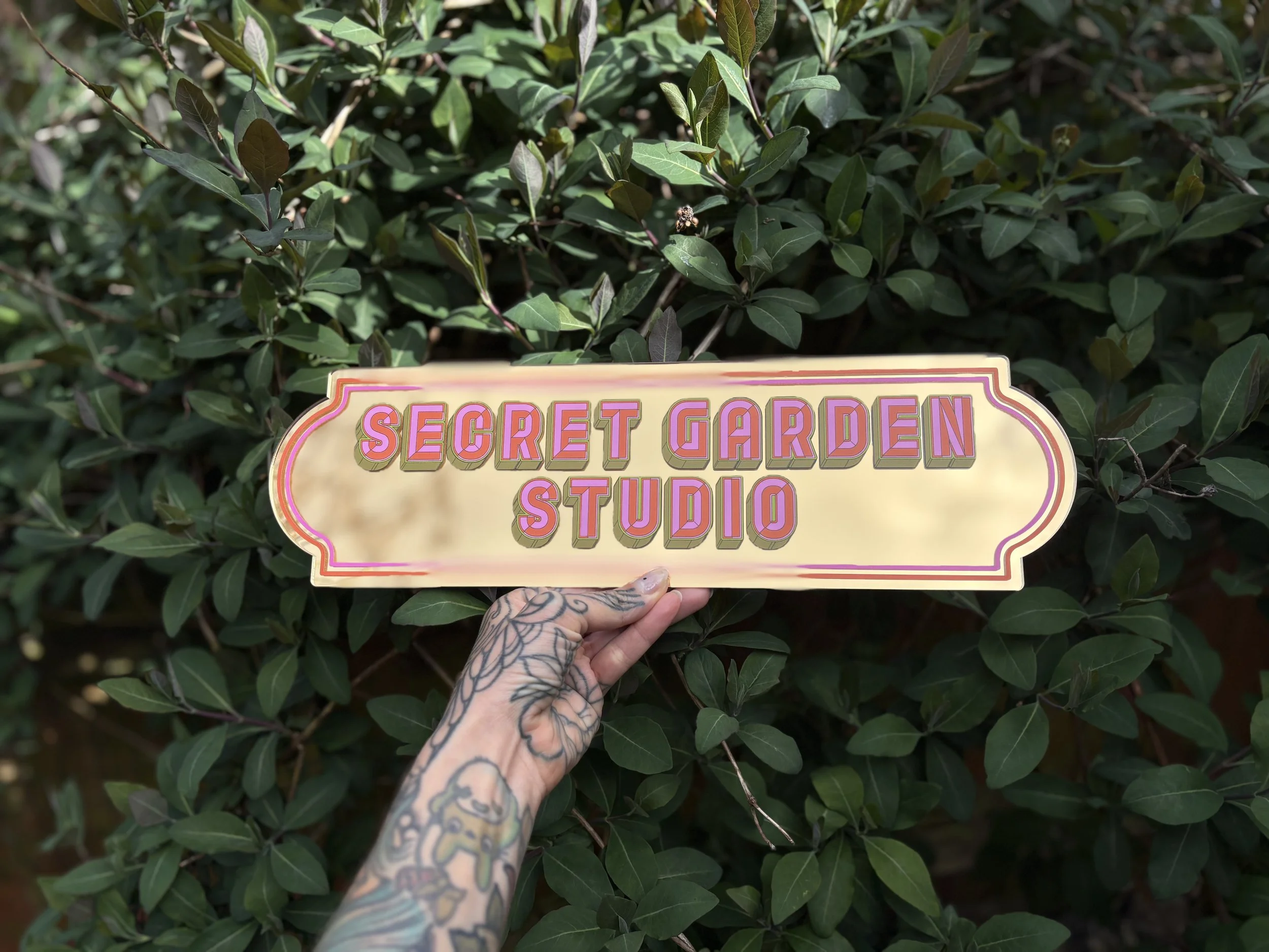 Secret garden studio sign green foliage gold and pink