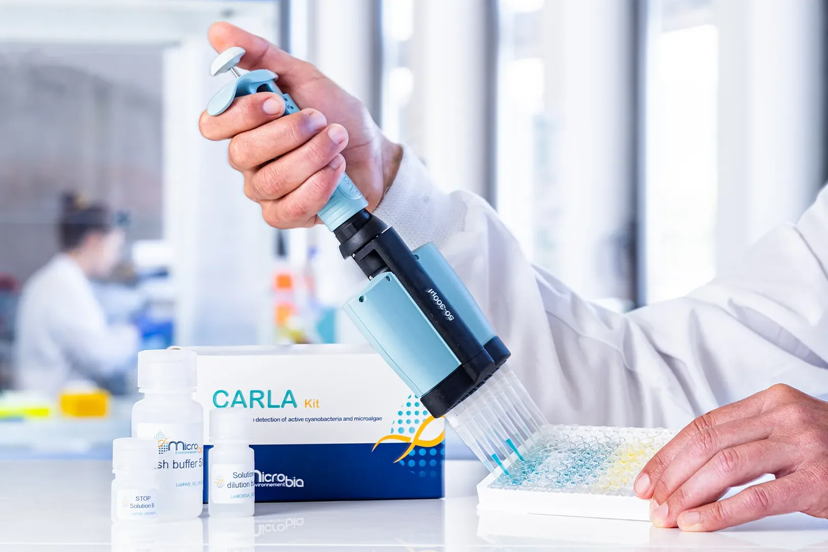 Chercheur utilisant un amplificateur d'ADN dans un laboratoire avec un kit de détection de cyanobactéries, pipettes et bouteilles de solutions