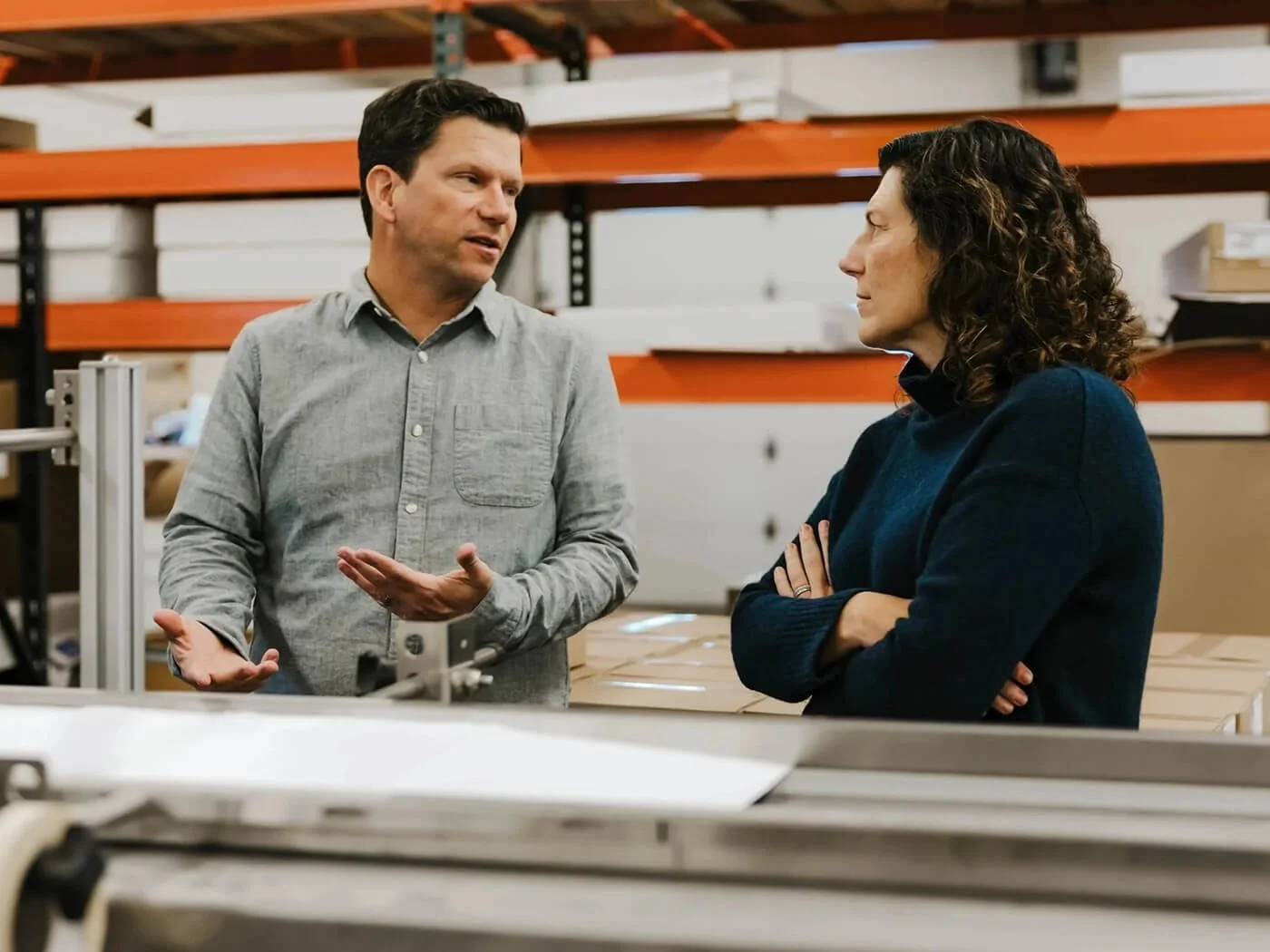 Team members discussing operations together on a manufacturing floor, reflecting a collaborative partnership approach.