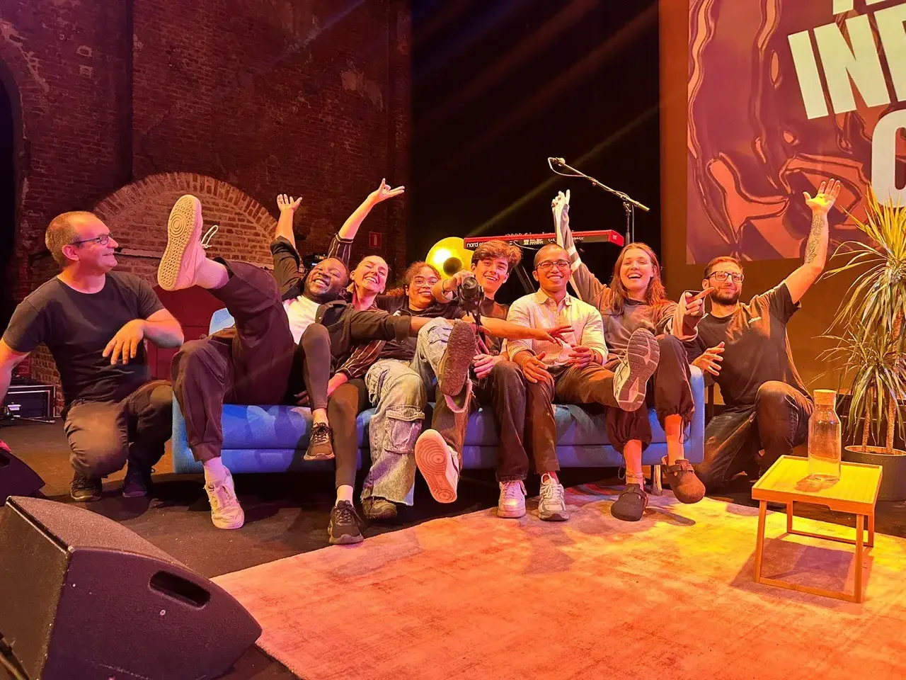 TMG Belgium team photo: Samuel Vekeman and the TMG Belgium crew on stage at a live event venue in Antwerp.
