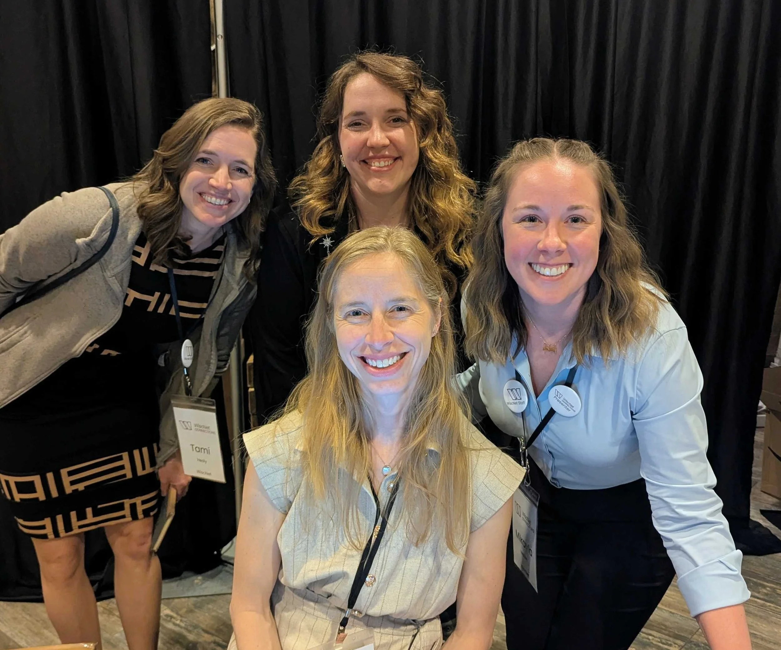 Four smiling women wearing lanyards