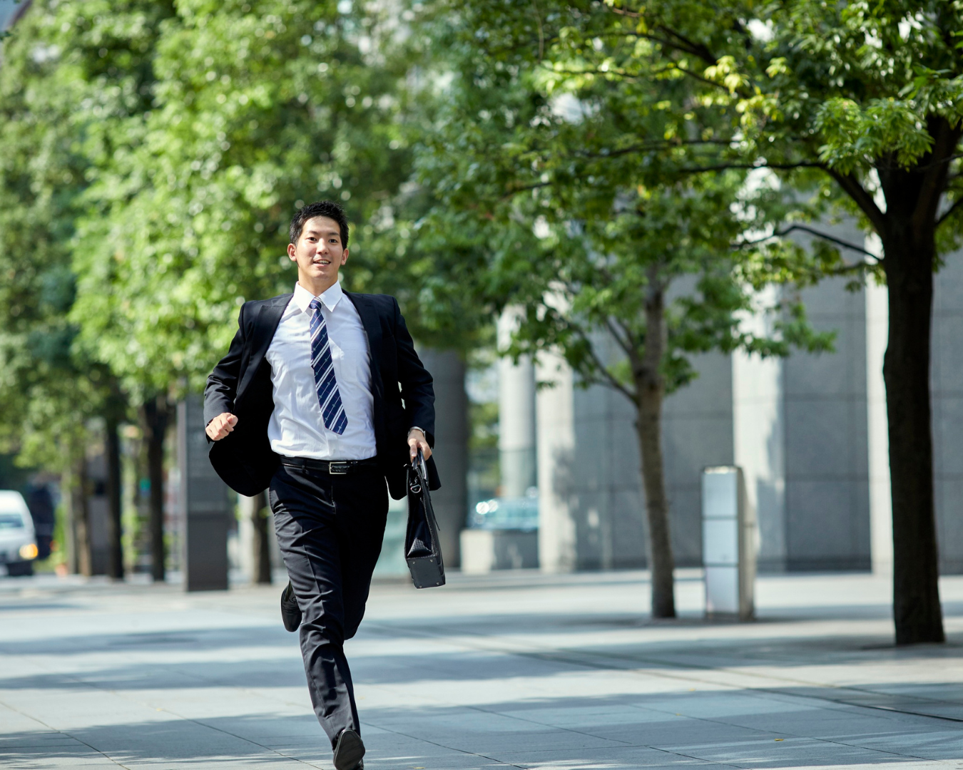 Molecoolar - A young man in a business suit running on a city sidewalk surrounded by trees representing entrepreneurs struggling to have out-of-this-world brands.