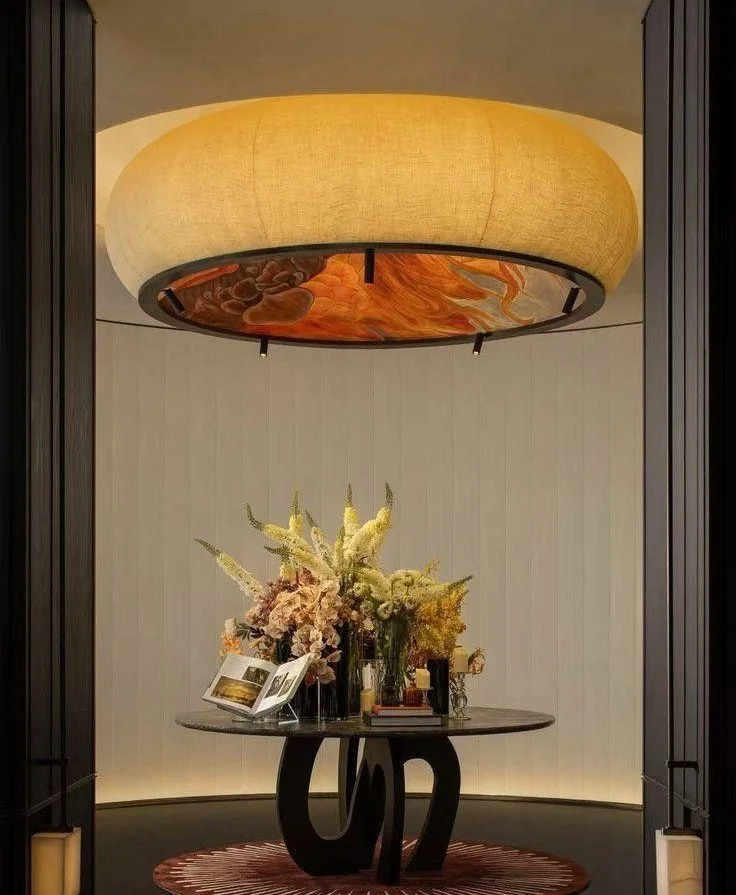 Sculptural chandelier above marble table in refined interior setting