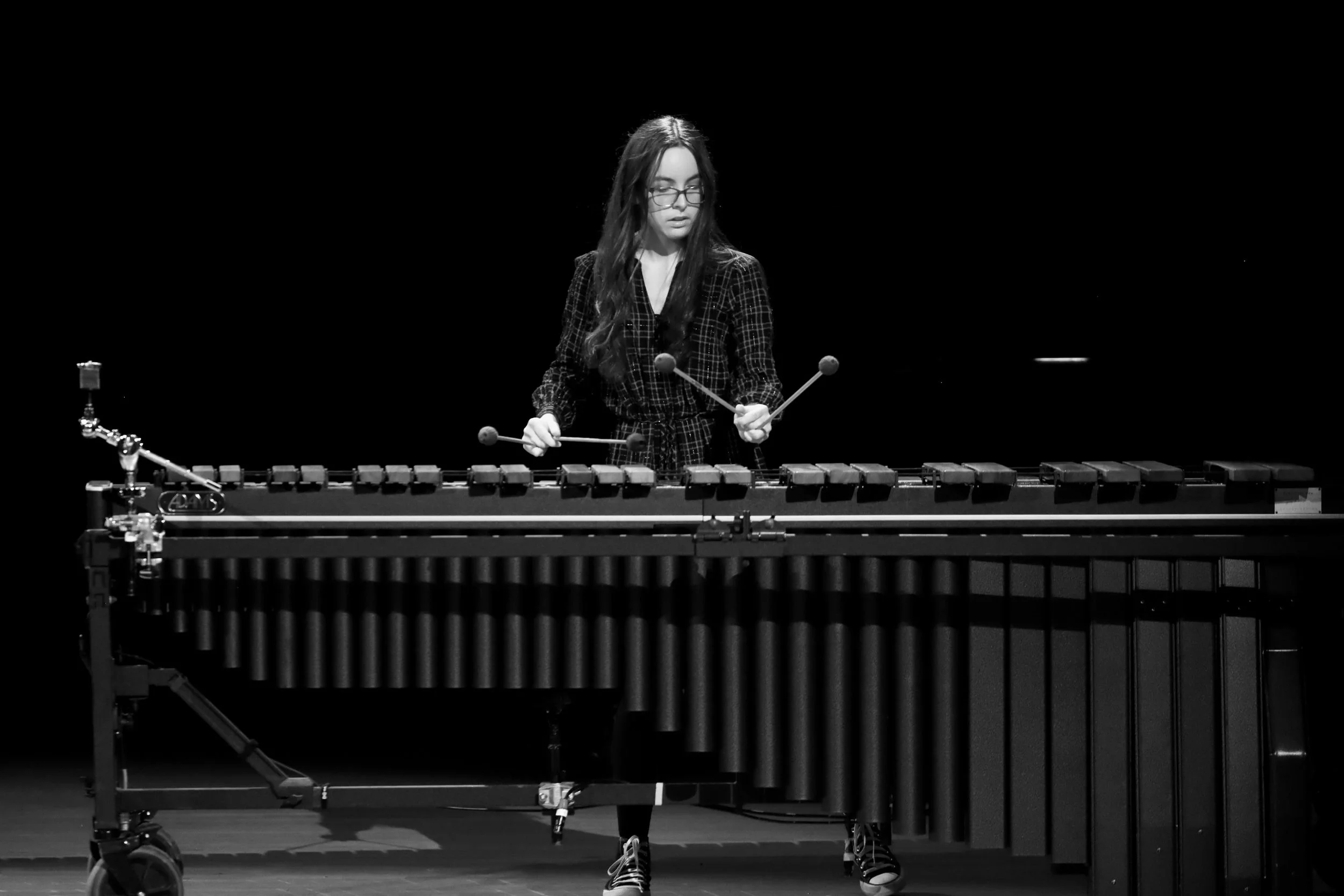 A woman playing a vibraphone on a black background
