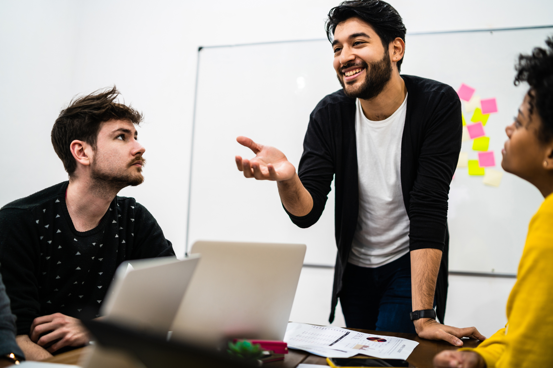 Manager leading a team meeting, explaining ideas and engaging colleagues around a conference table.