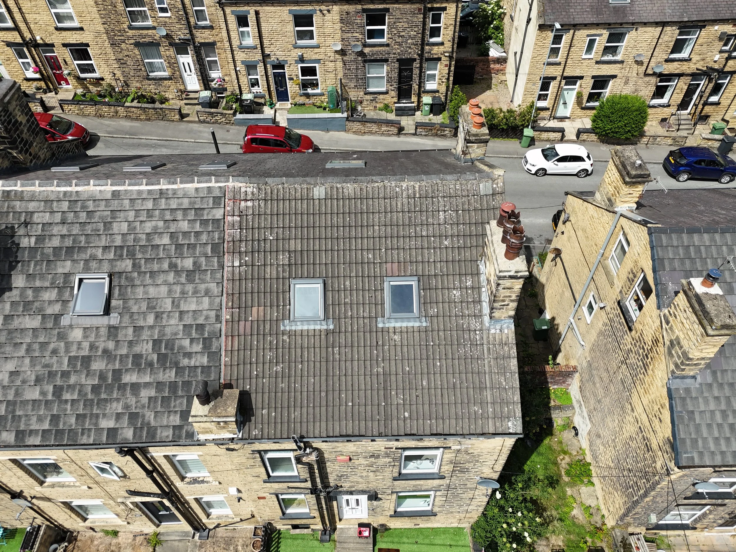 Tiled roof on an end terrace house being inspected