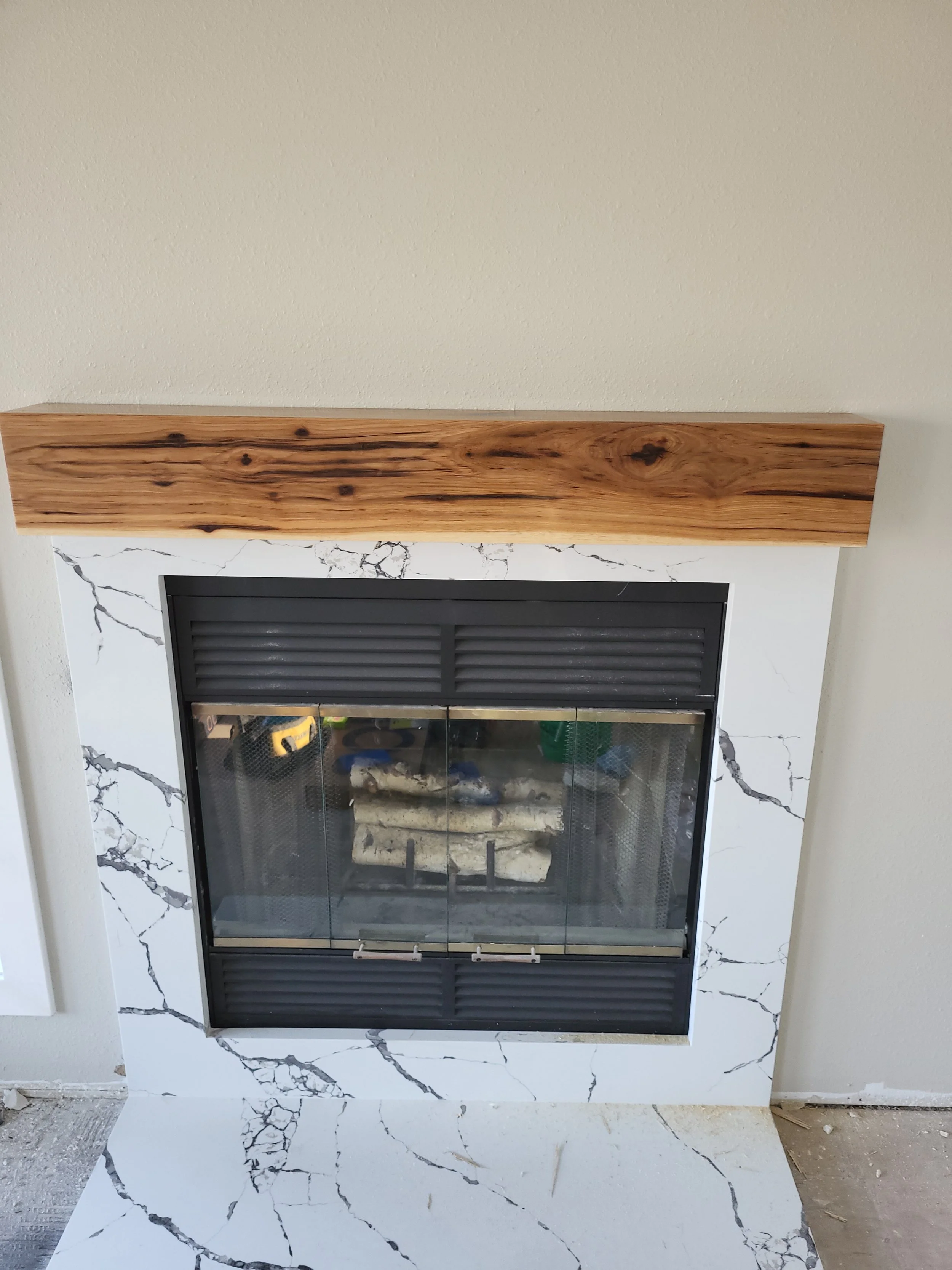 Custom fireplace with quartz surround and Mantle made from solid Hickory resourced from Webster City.