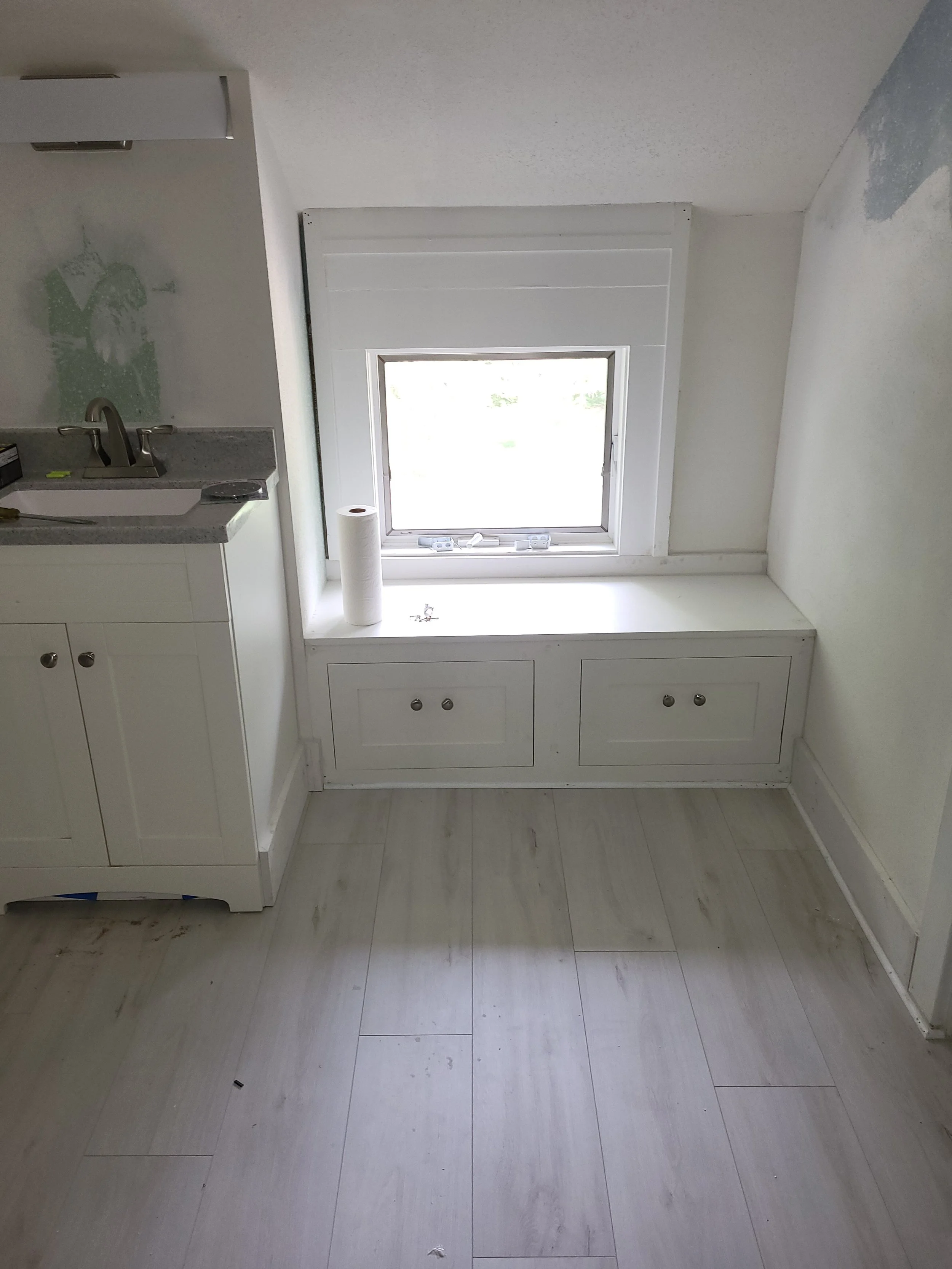 Bathroom renovation with new vanity, shower, flooring and bench.
