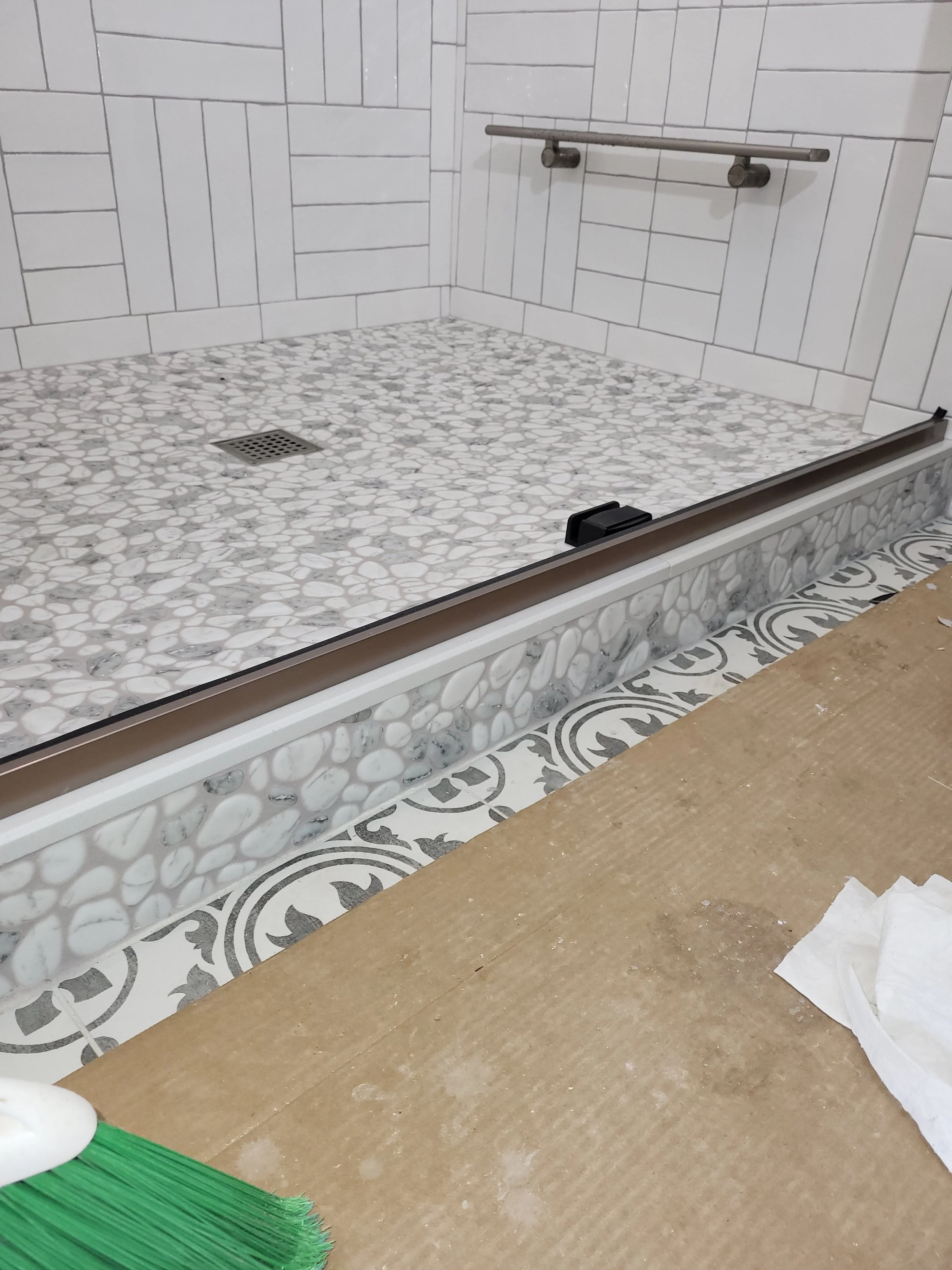 Bathroom shower with white pebble tile flooring