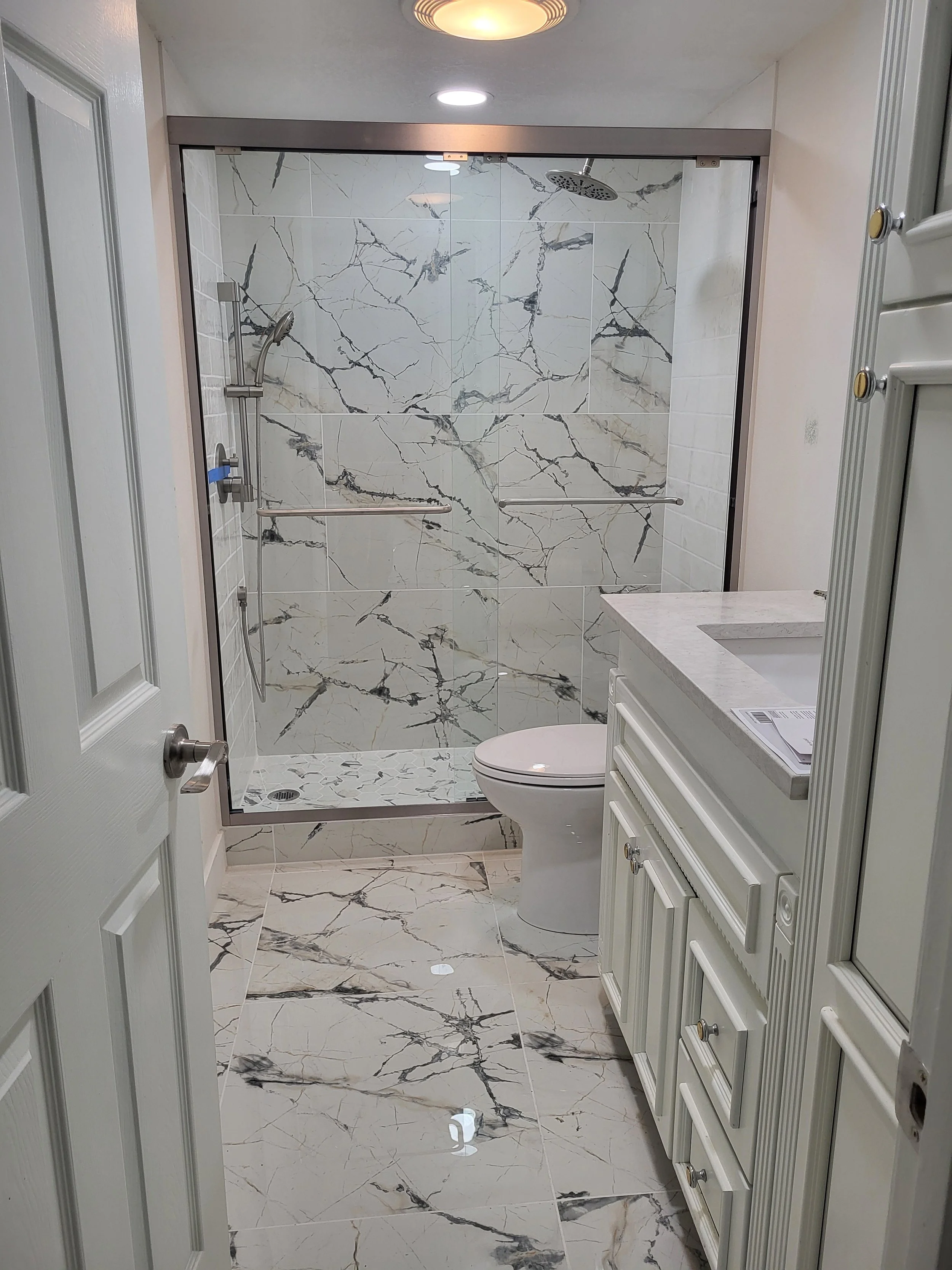 A renovated secondary bathroom with left hand drain using a precast tileable drain pan.