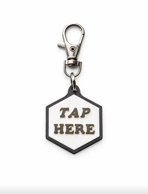 Keychain with a hexagonal tag that says 'TAP HERE' hanging from a metal clasp.