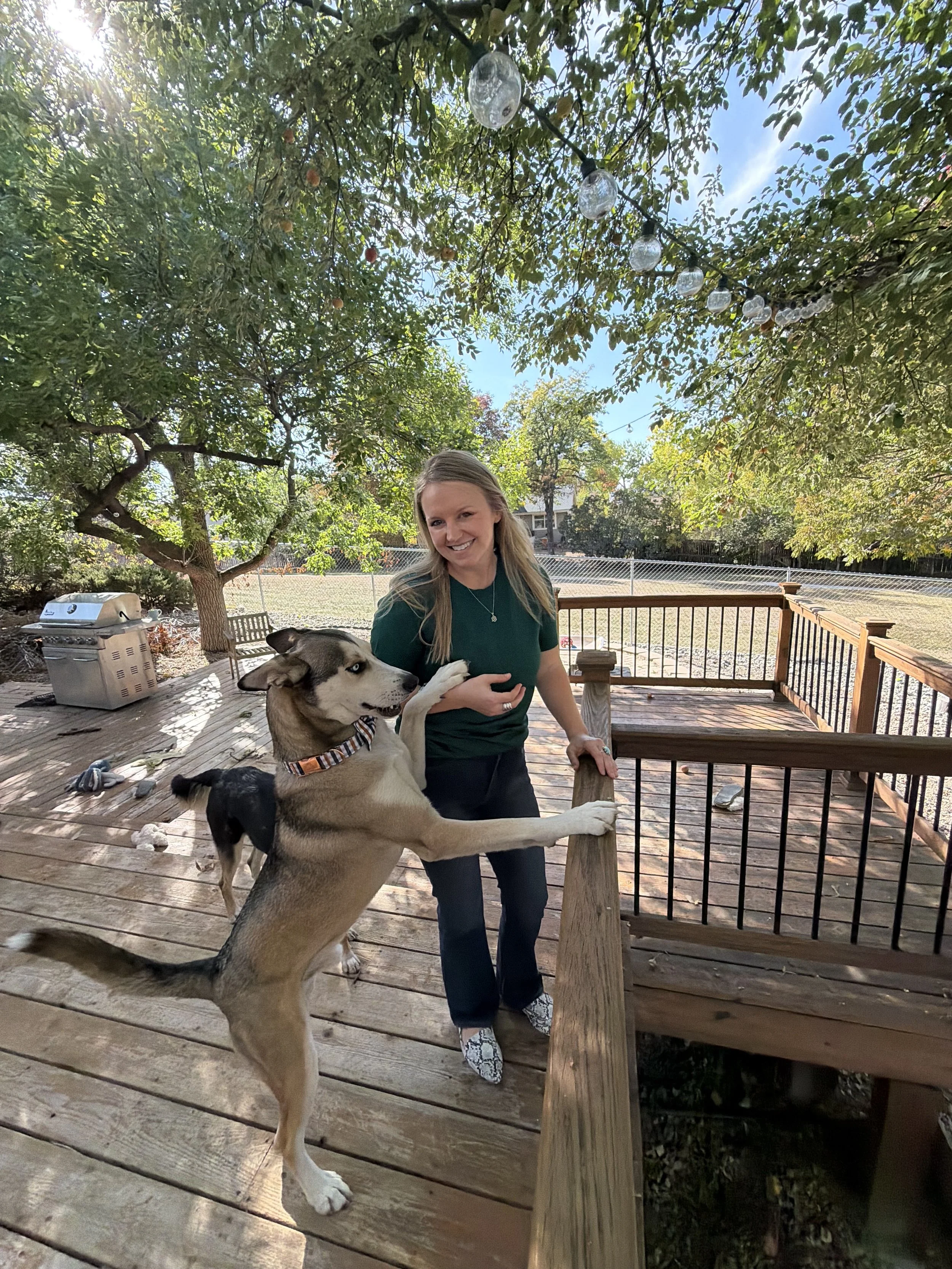 A holistic therapist smiling with her dog working with high performing women, executives and leaders