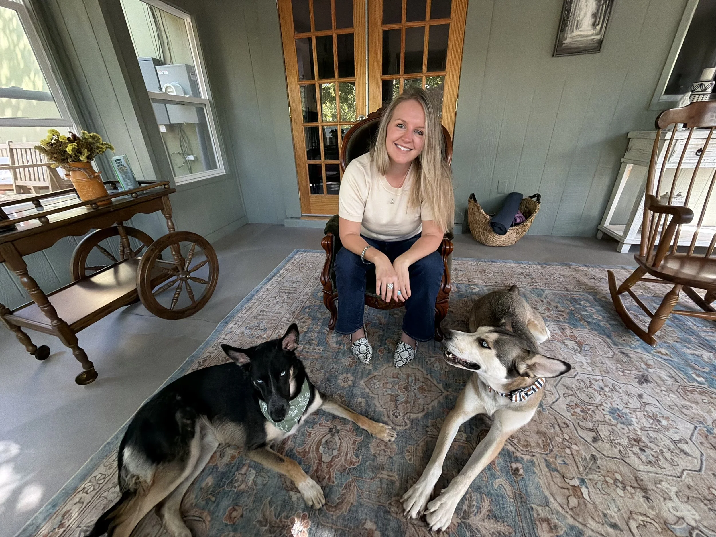 A San Francisco Therapist sitting in her sunroom with her 2 dogs, smiling