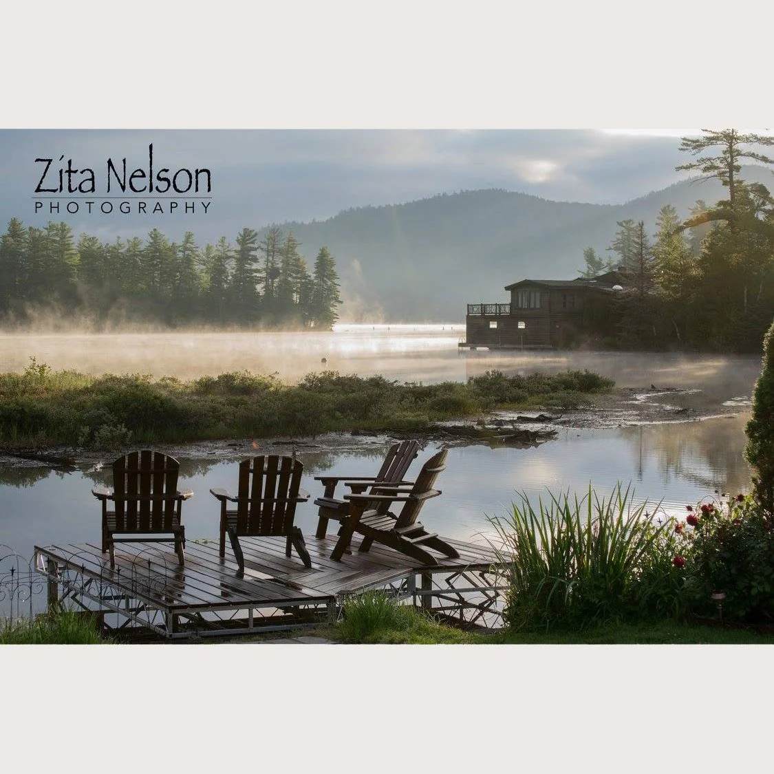 Photograph of morning steam on the lake with adirondack chairs and lake reflection of mountains in Lake Placid, NY