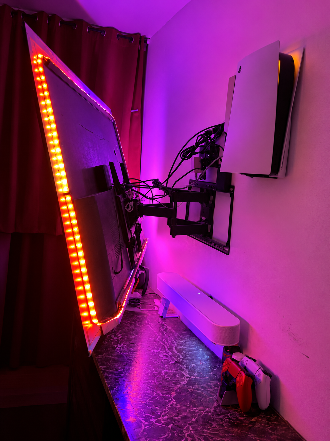 Purple-lit TV mount with PlayStation 5.png