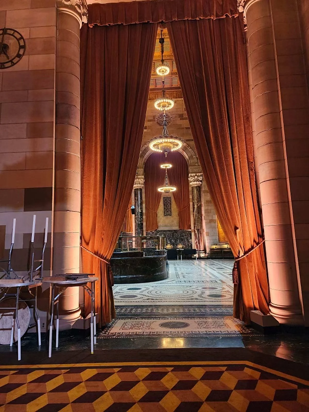 Rust velvet drapery with tassel tiebacks framing a grand event hall entrance, NYC
